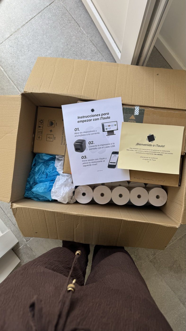 Caja de iTaula abierta con la impresora de tickets, los rollos de papel y la hoja de instrucciones de instalación