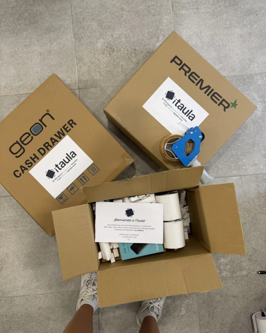 Kit de iTaula para eventos en sus cajas: cajón portamonedas, impresora y caja abierta con la tarjeta de bienvenida y los rollos de papel
